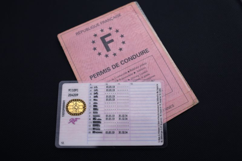 Responsable RH consultant un dossier d’un cadre itinérant ayant perdu son permis de conduire, dans un bureau moderne