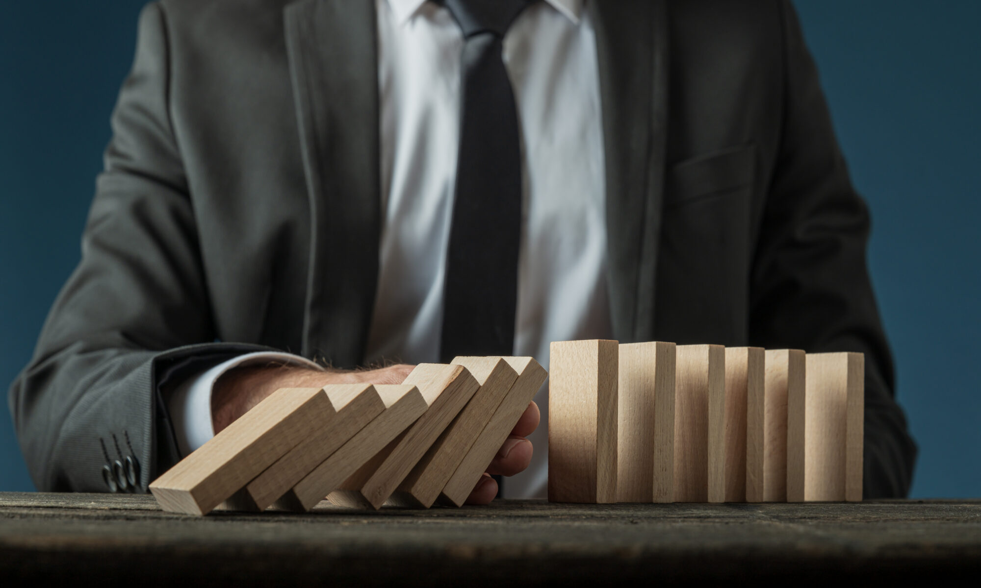 Dirigeant d’entreprise consultant un rapport financier dans son bureau, préoccupé par les difficultés économiques liées à sa gestion