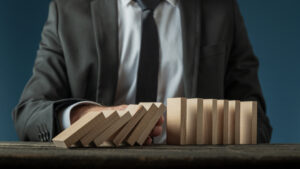 Dirigeant d’entreprise consultant un rapport financier dans son bureau, préoccupé par les difficultés économiques liées à sa gestion